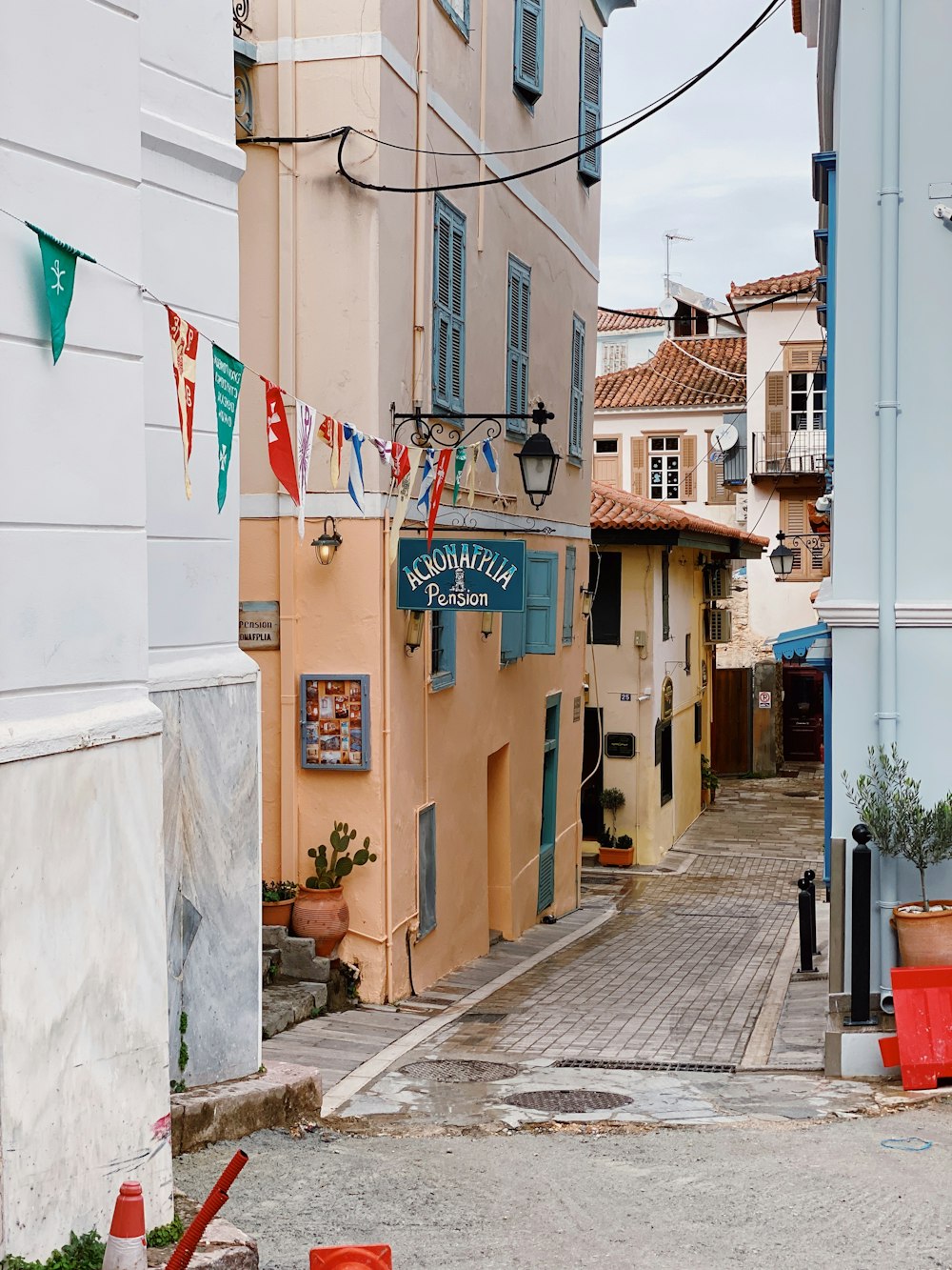 a narrow street with buildings and flags on the side of it