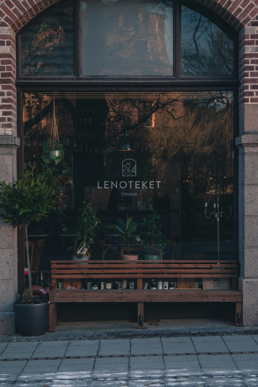 a wooden bench sitting in front of a window