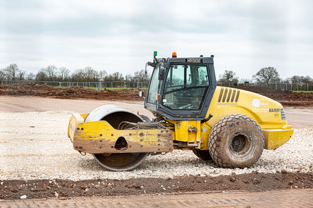 a yellow bulldozer is parked on a dirt road