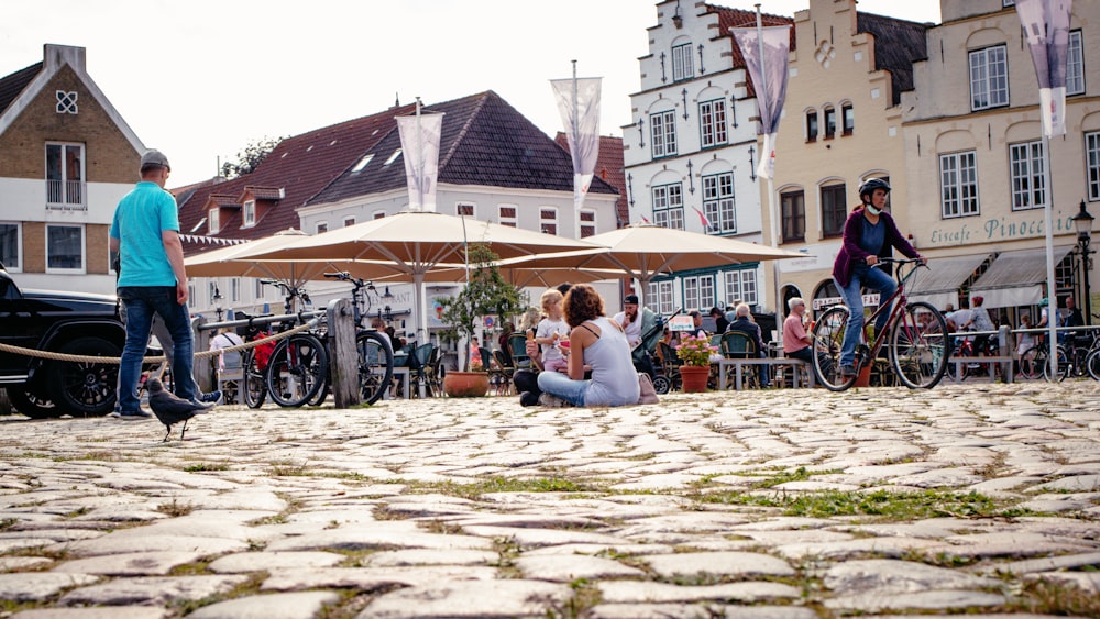 a group of people standing around a cobblestone street