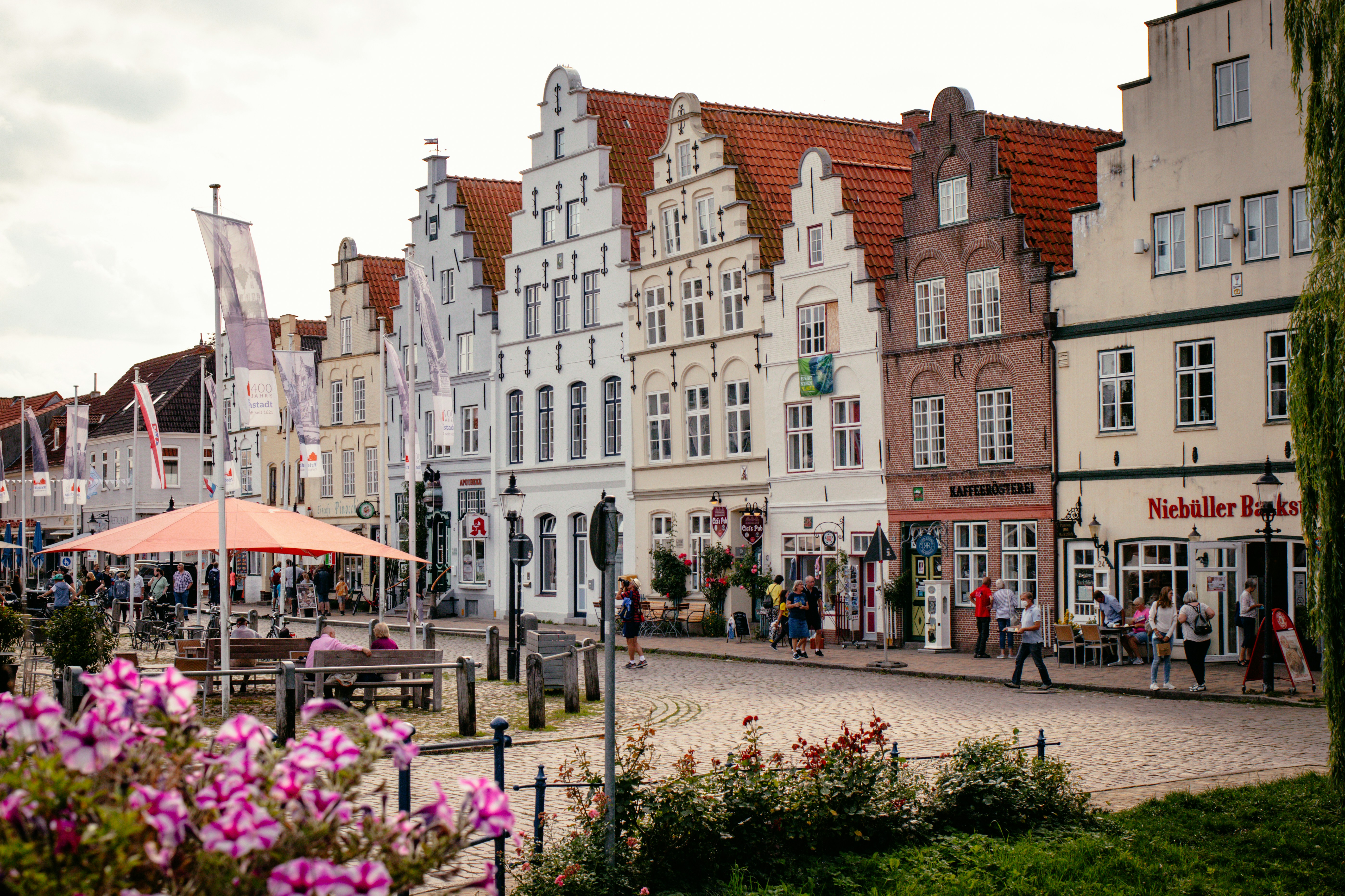 a group of people walking down a street next to tall buildings