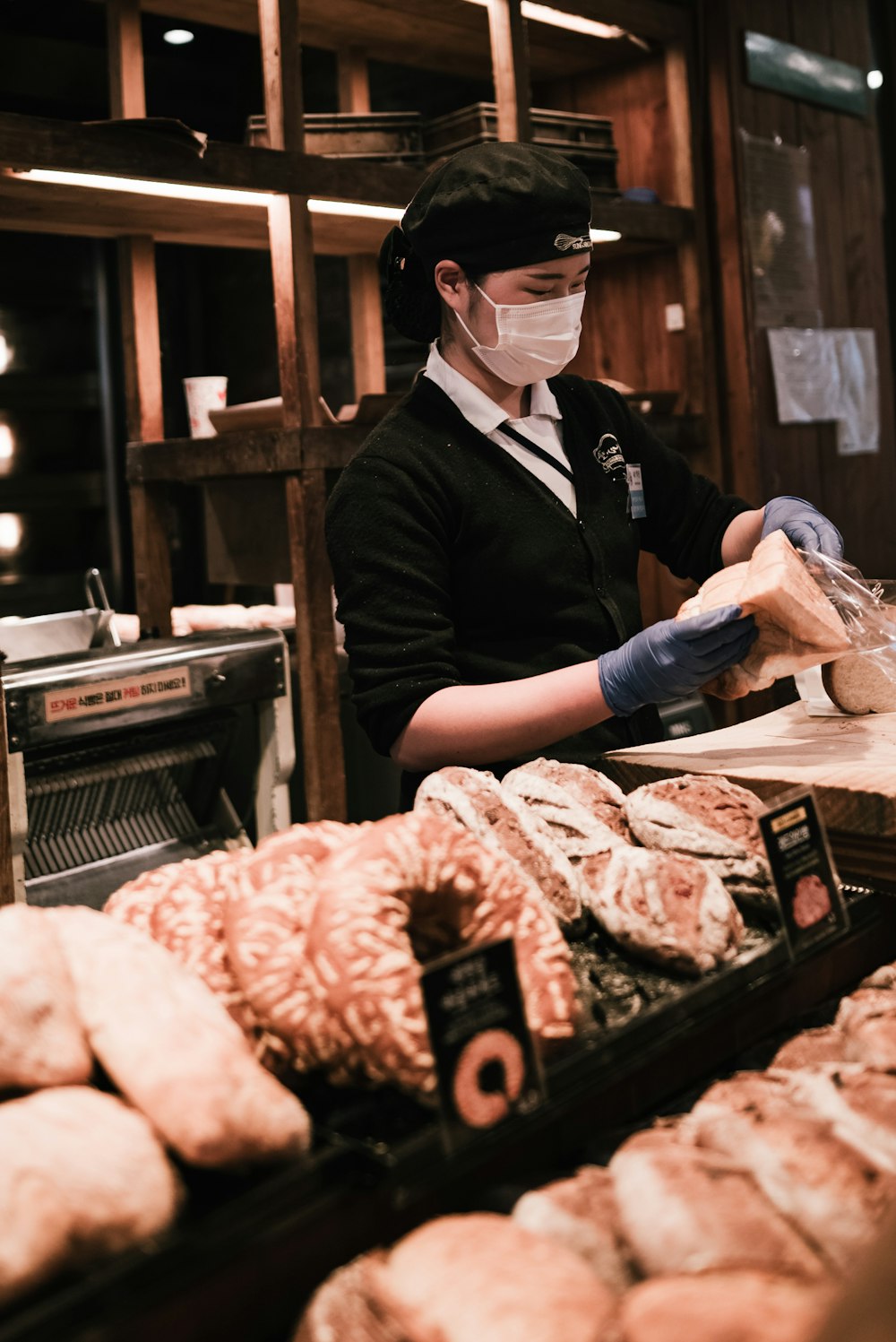 a person wearing a face mask and gloves in a bakery