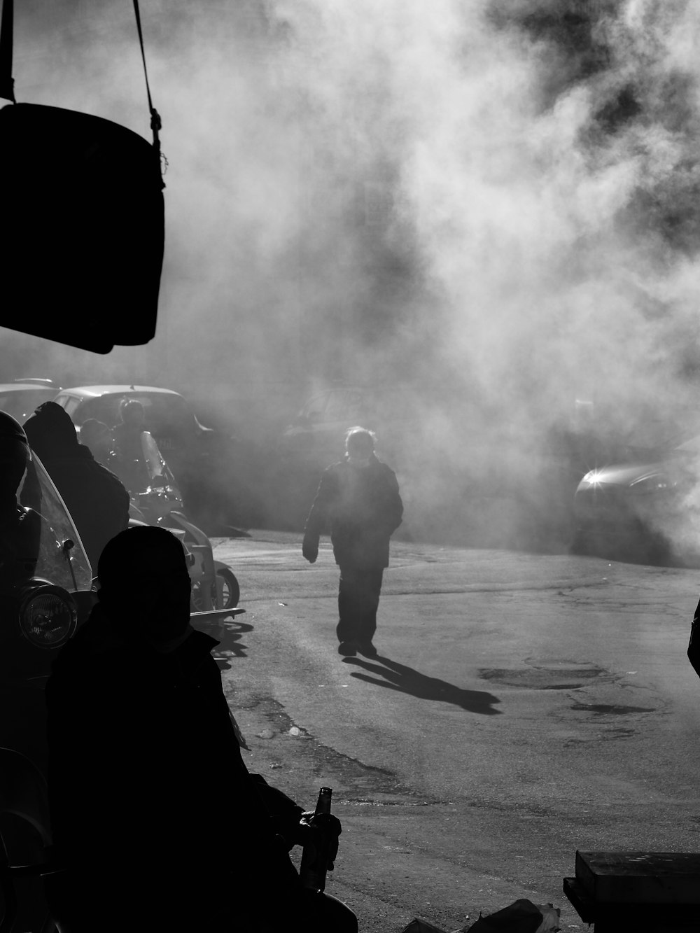 a black and white photo of a person walking in a parking lot