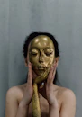 a woman with a gold mask covering her face