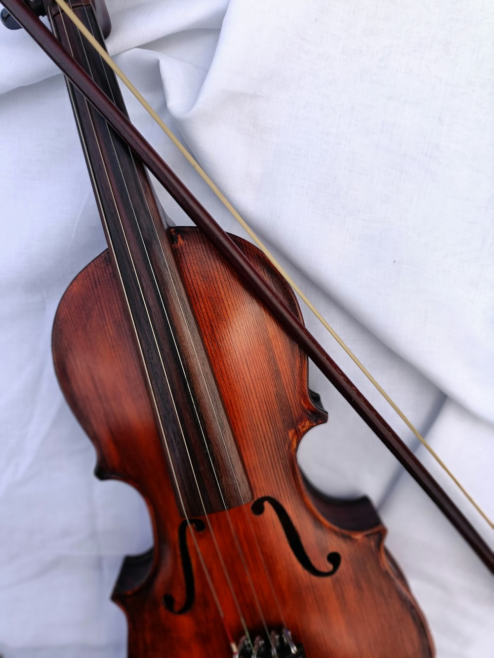 a close up of a violin on a white sheet