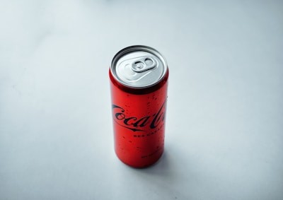 Close-up of a Red Bull can opener with a vintage patina on a dark background.