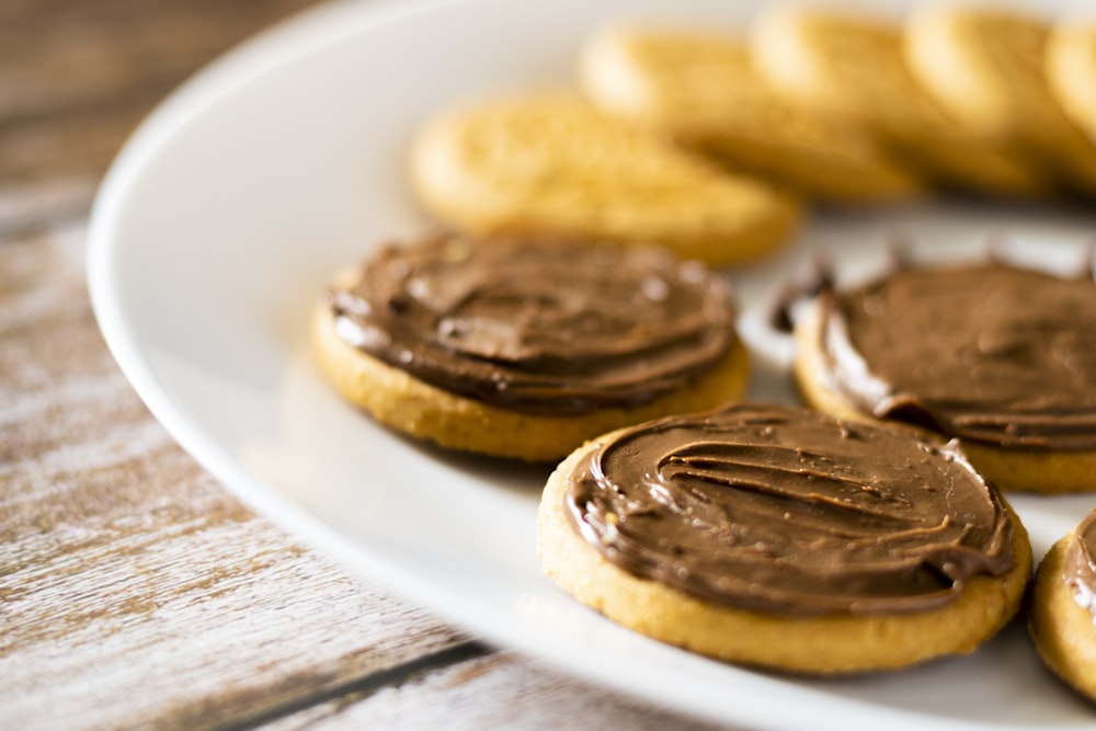 a white plate topped with cookies covered in chocolate frosting