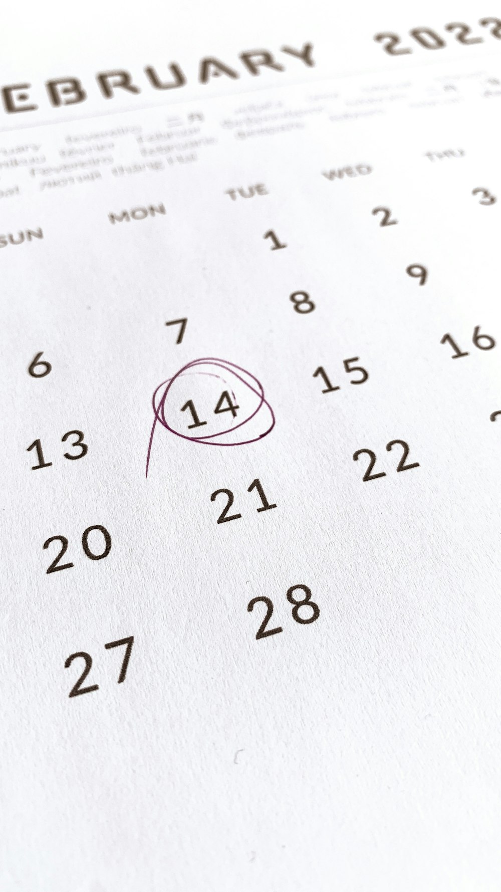 a close up of a calendar with a red marker