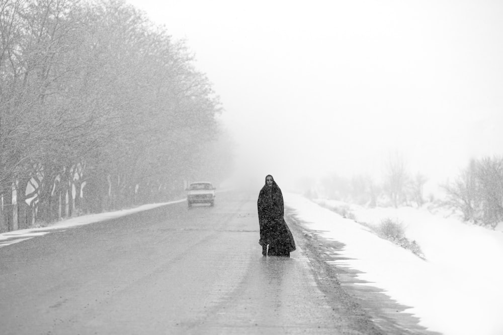 a person walking down a road in the snow