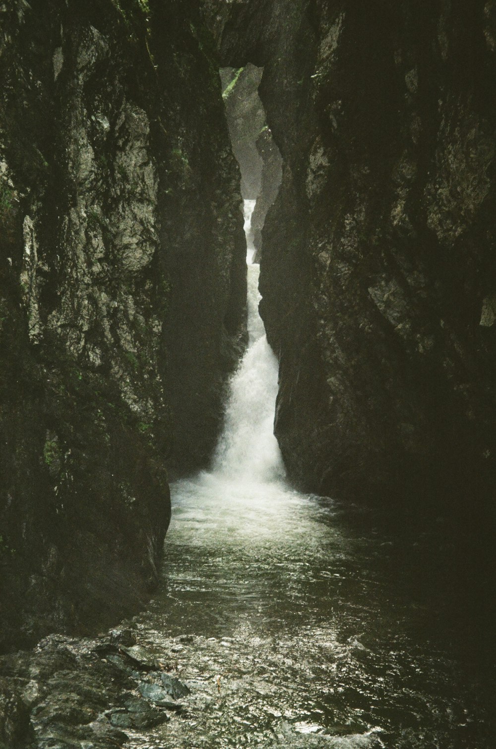 a narrow river flowing between two large rocks