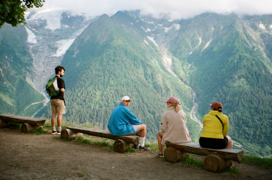 a group of people sitting on top of a wooden bench