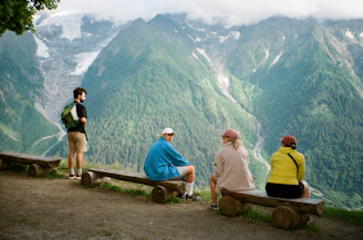 a group of people sitting on top of a wooden bench