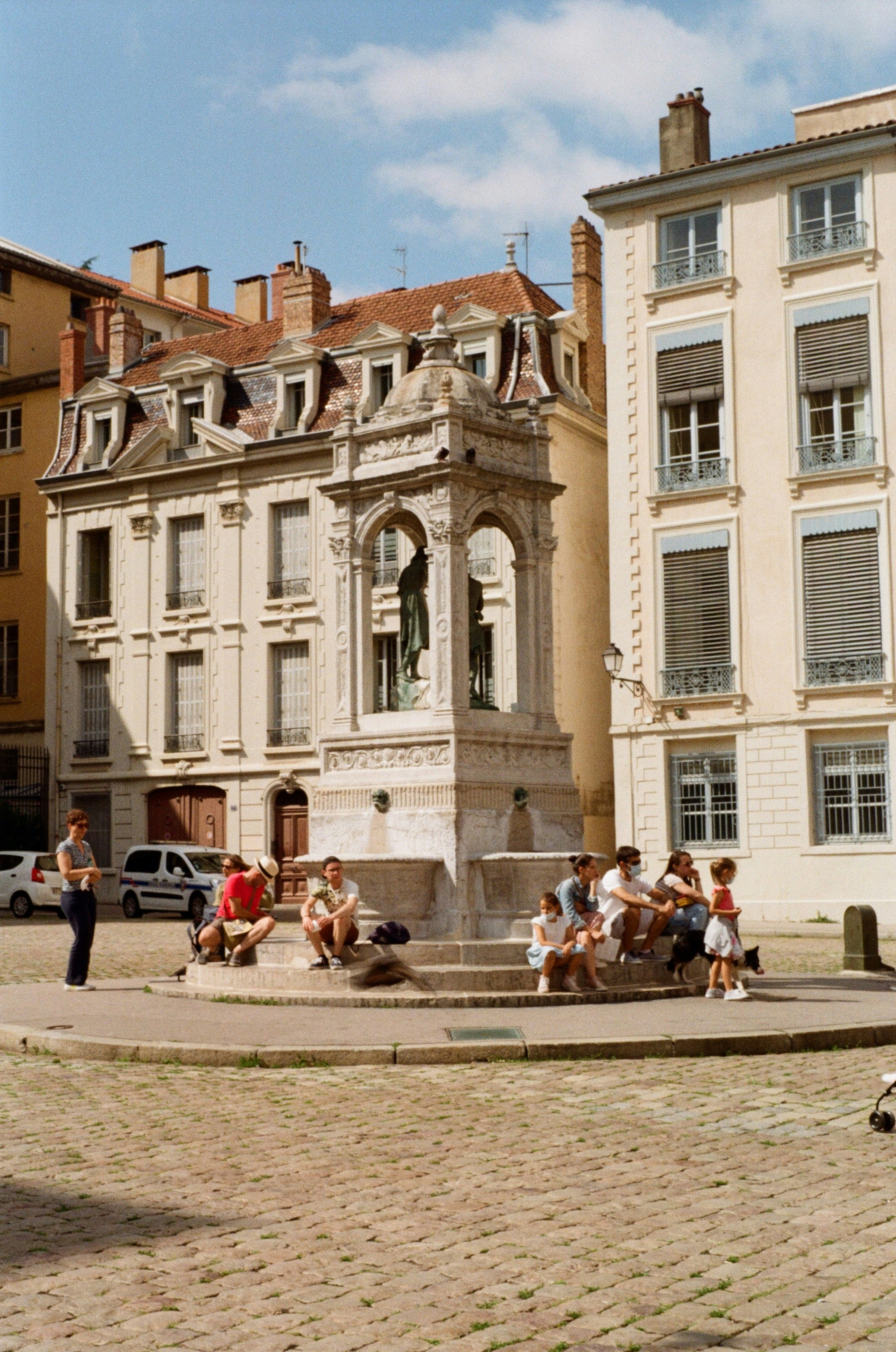 Un groupe de personnes assises sur un banc devant un bâtiment photo ...