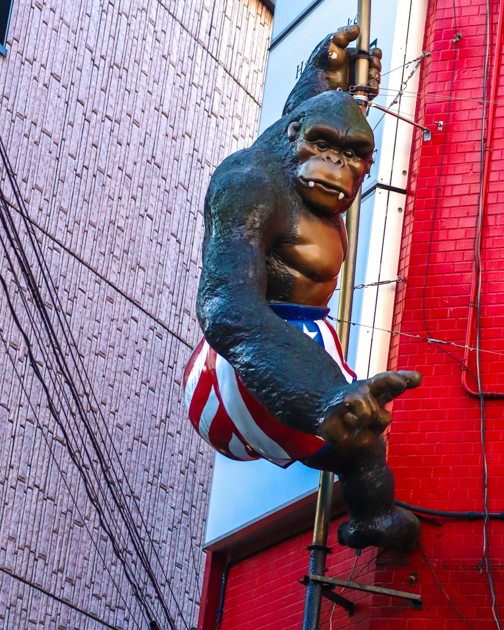 a statue of a gorilla hanging from a building