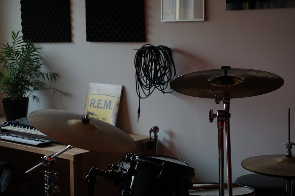 a drum set up in a room with a plant