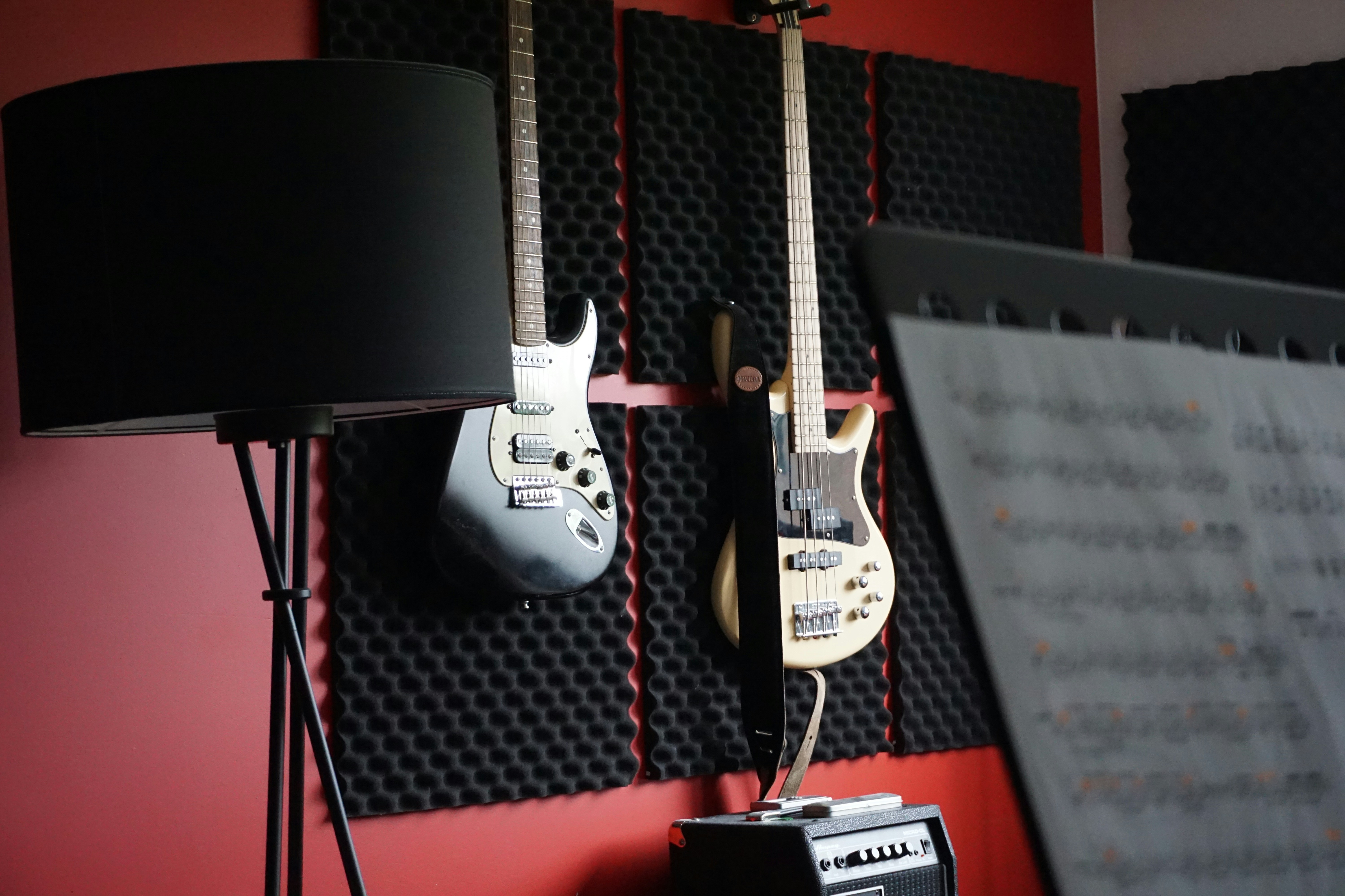 Elektriske guitarer hænger på en studievæg med lydpaneler.