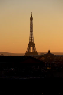 A vibrant photo of the Eiffel Tower glowing at sunset with a warm sky.