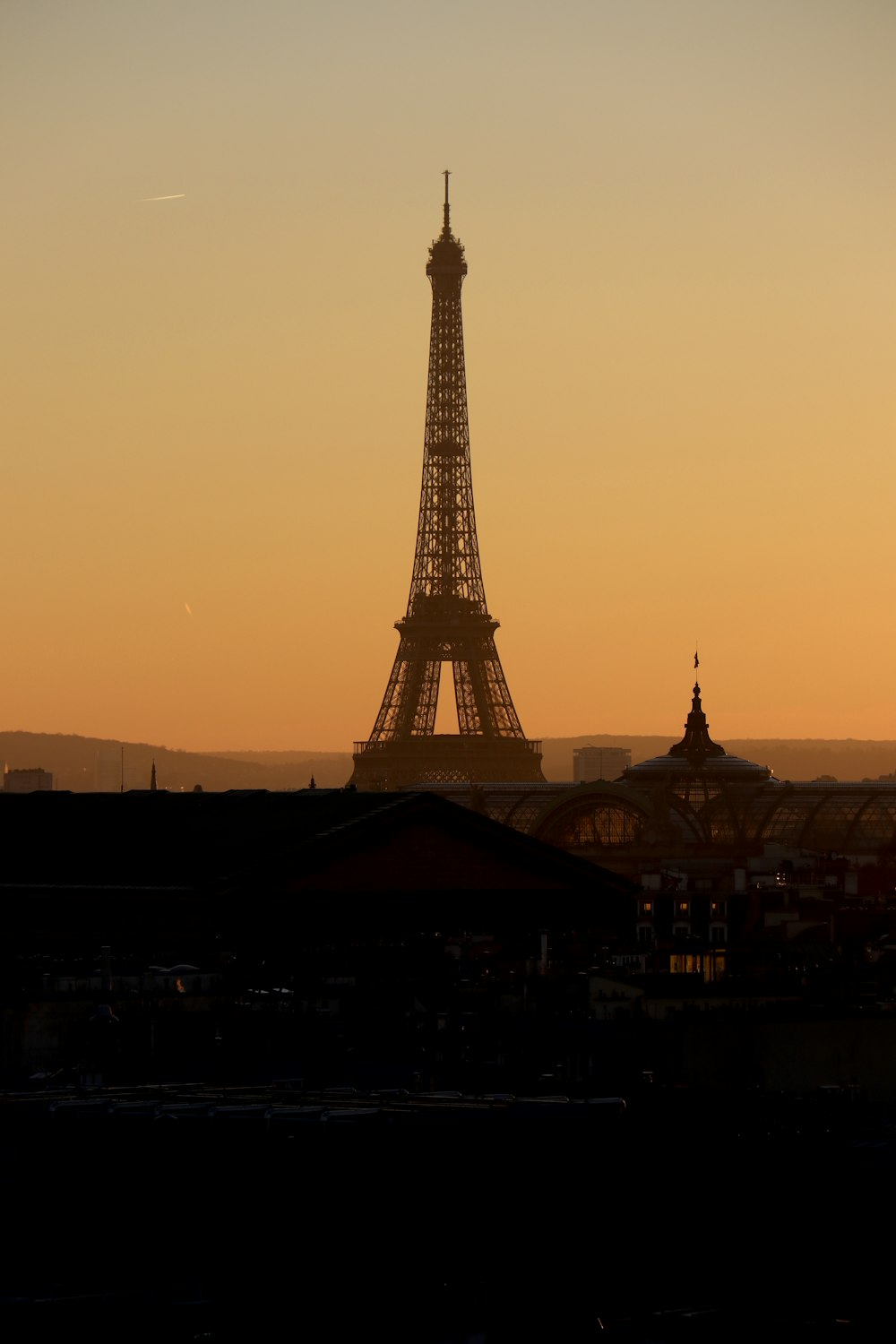 the eiffel tower is silhouetted against the sunset