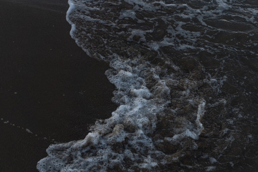 a black sand beach with waves coming in to shore