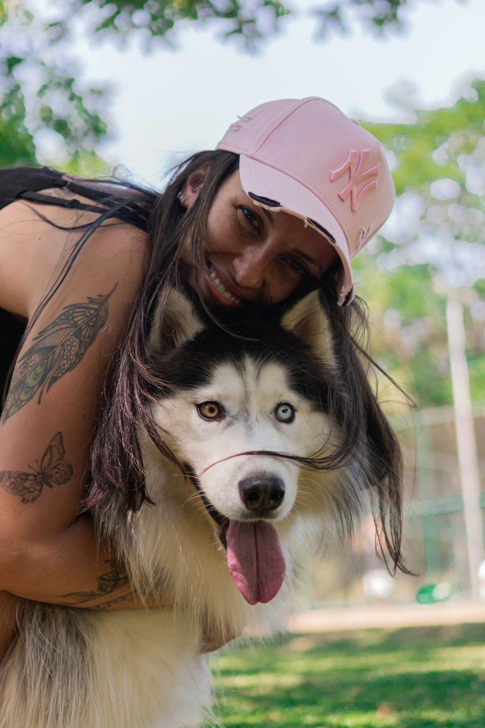 a woman hugging a husky dog in a park