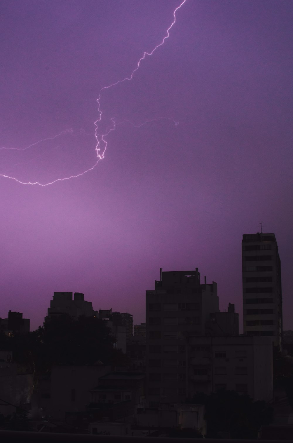a purple sky with a lightning bolt in the distance