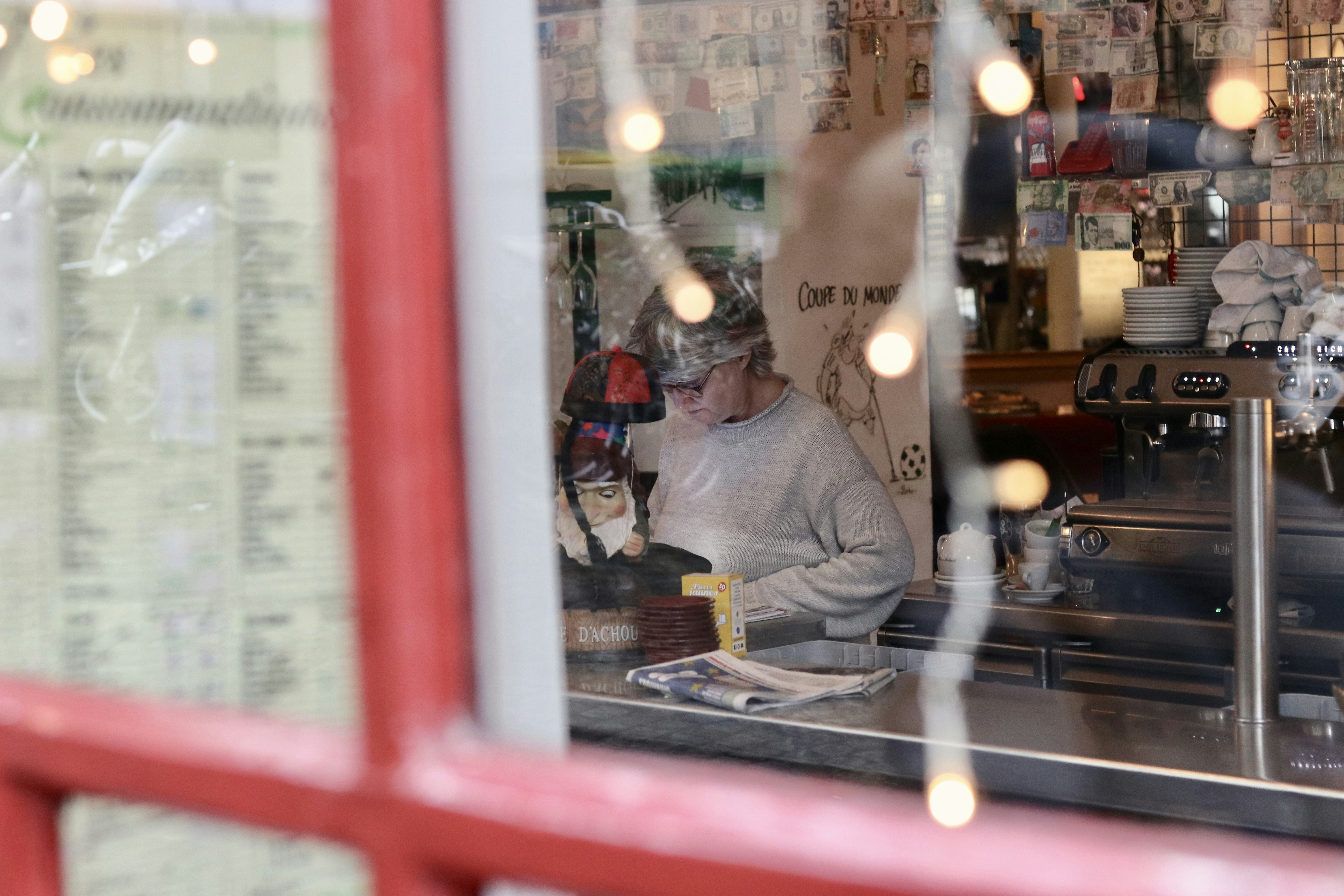 a woman sitting at a counter in a coffee shop