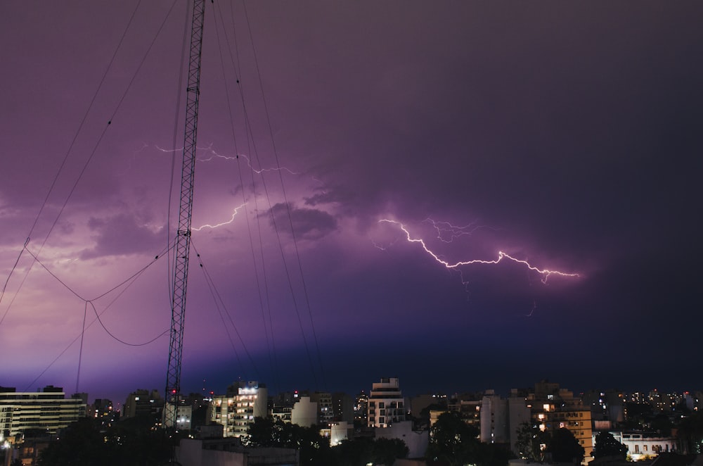 a lightning storm is seen over a city at night