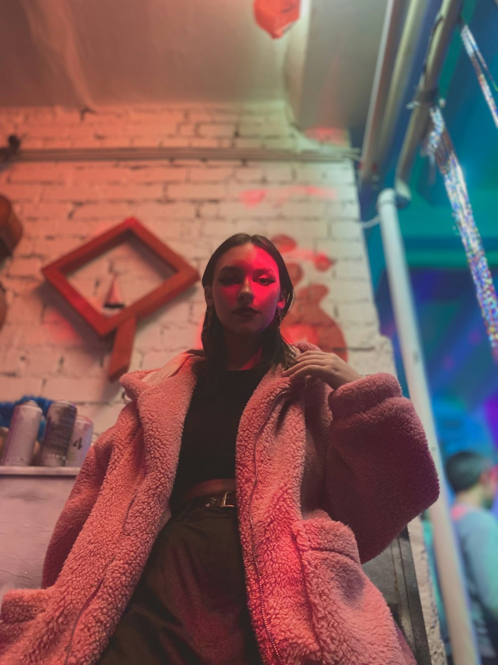 a woman in a pink coat is sitting down