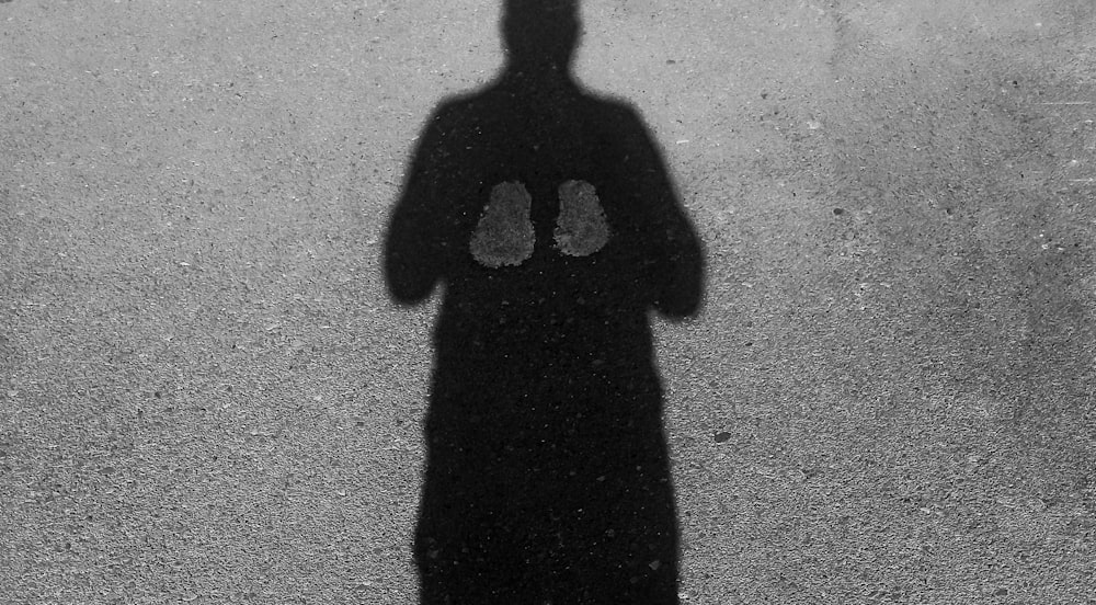 a shadow of a person standing in front of a wall