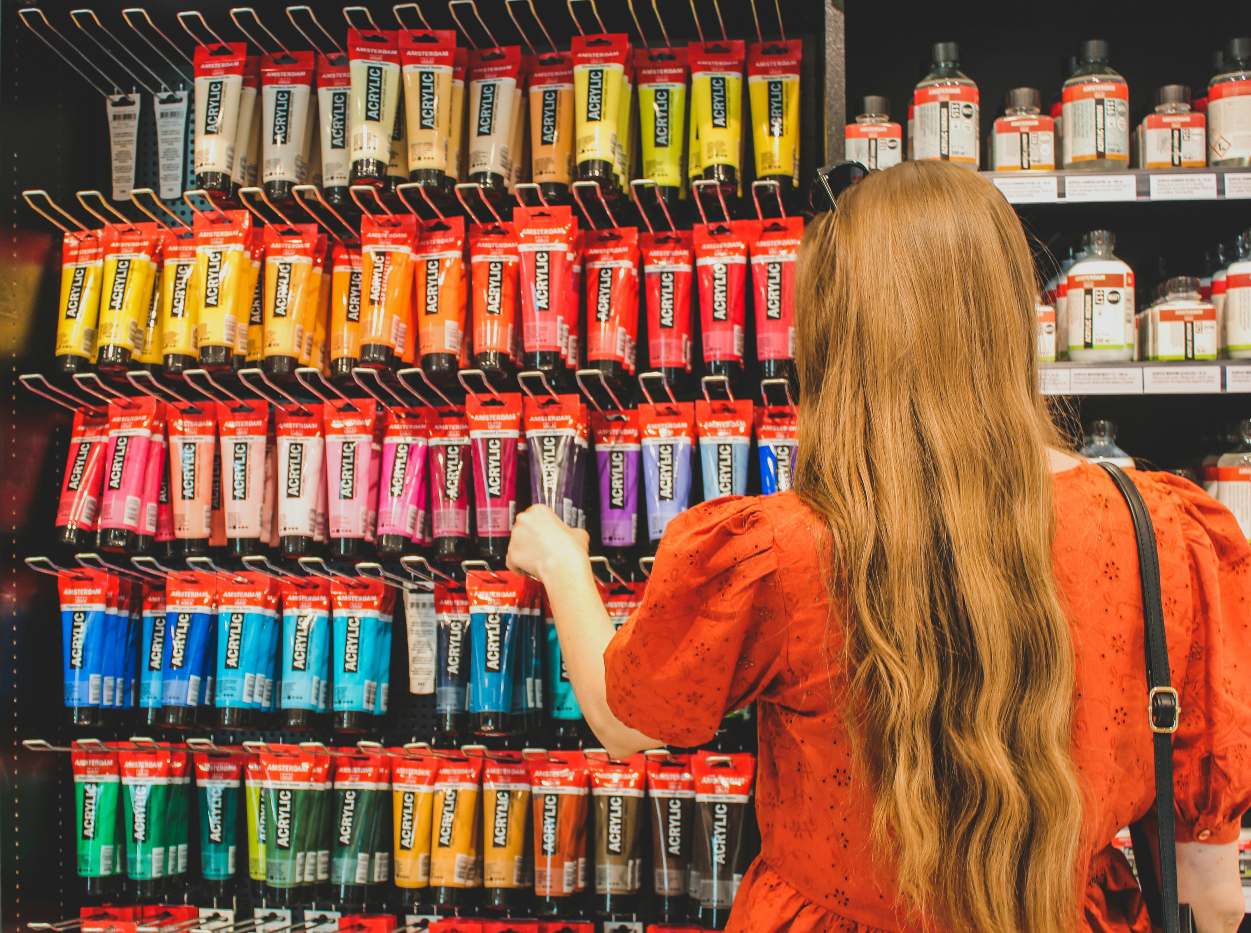 Sherwin-Williams paint store retail supply chain - a woman in a red dress is looking at a display of hair products