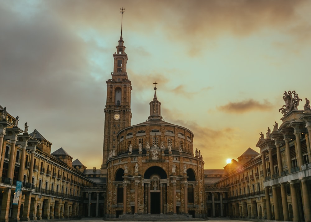 um grande edifício com uma torre do relógio no meio dele