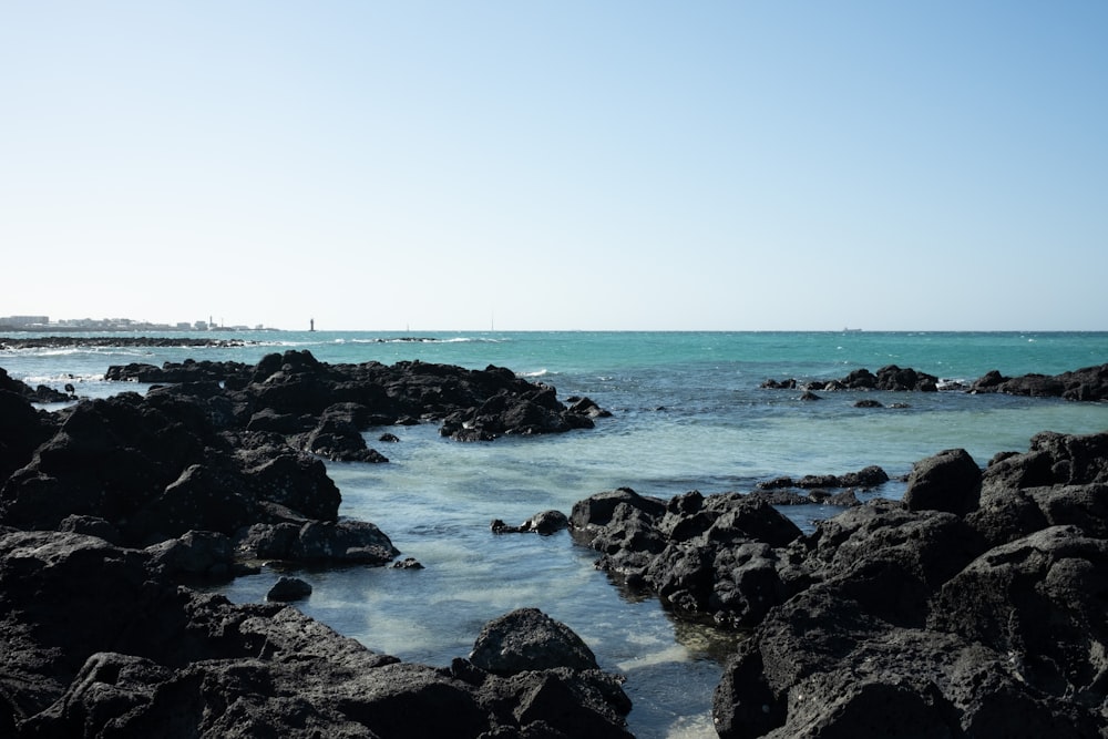 a body of water surrounded by rocks on a sunny day