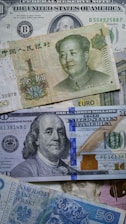 a pile of different types of money sitting on top of each other