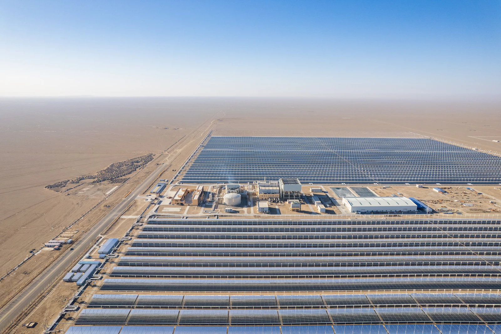 Vista aérea de planta solar industrial en desierto, analogía visual de H₂ verde + solar