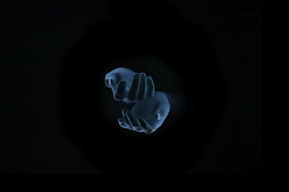 uma mão segurando algo em um quarto escuro