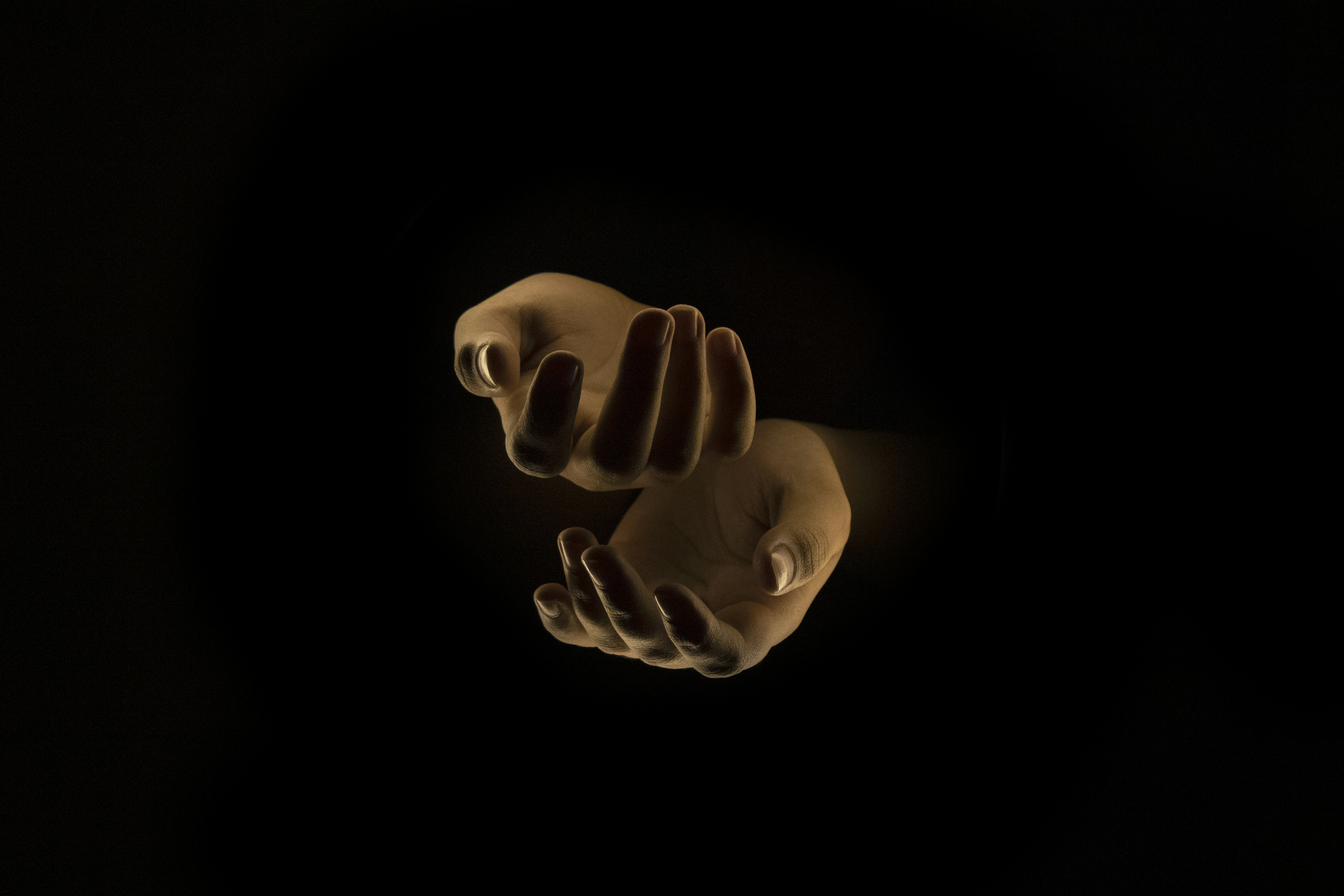 a hand holding something in a dark room