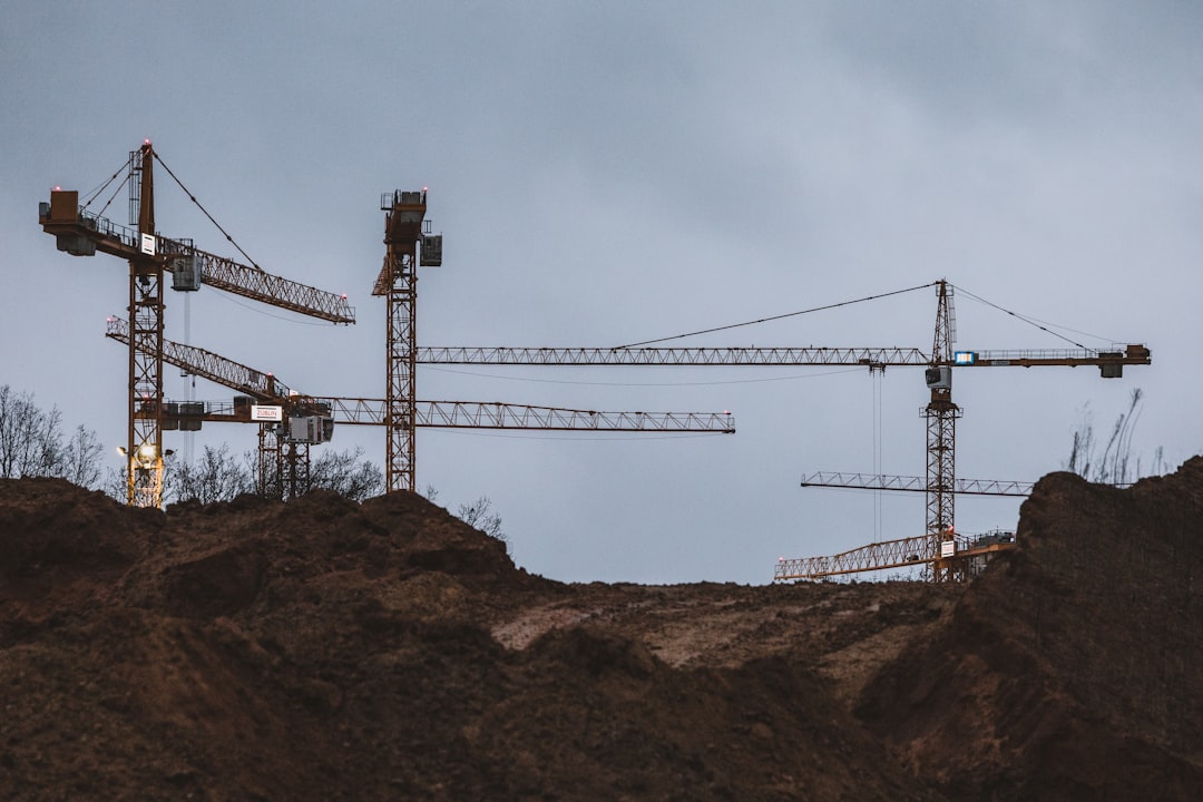 a group of cranes sitting on top of a hill, FAIR (Facility for Antiproton and Ion Research) construction site
