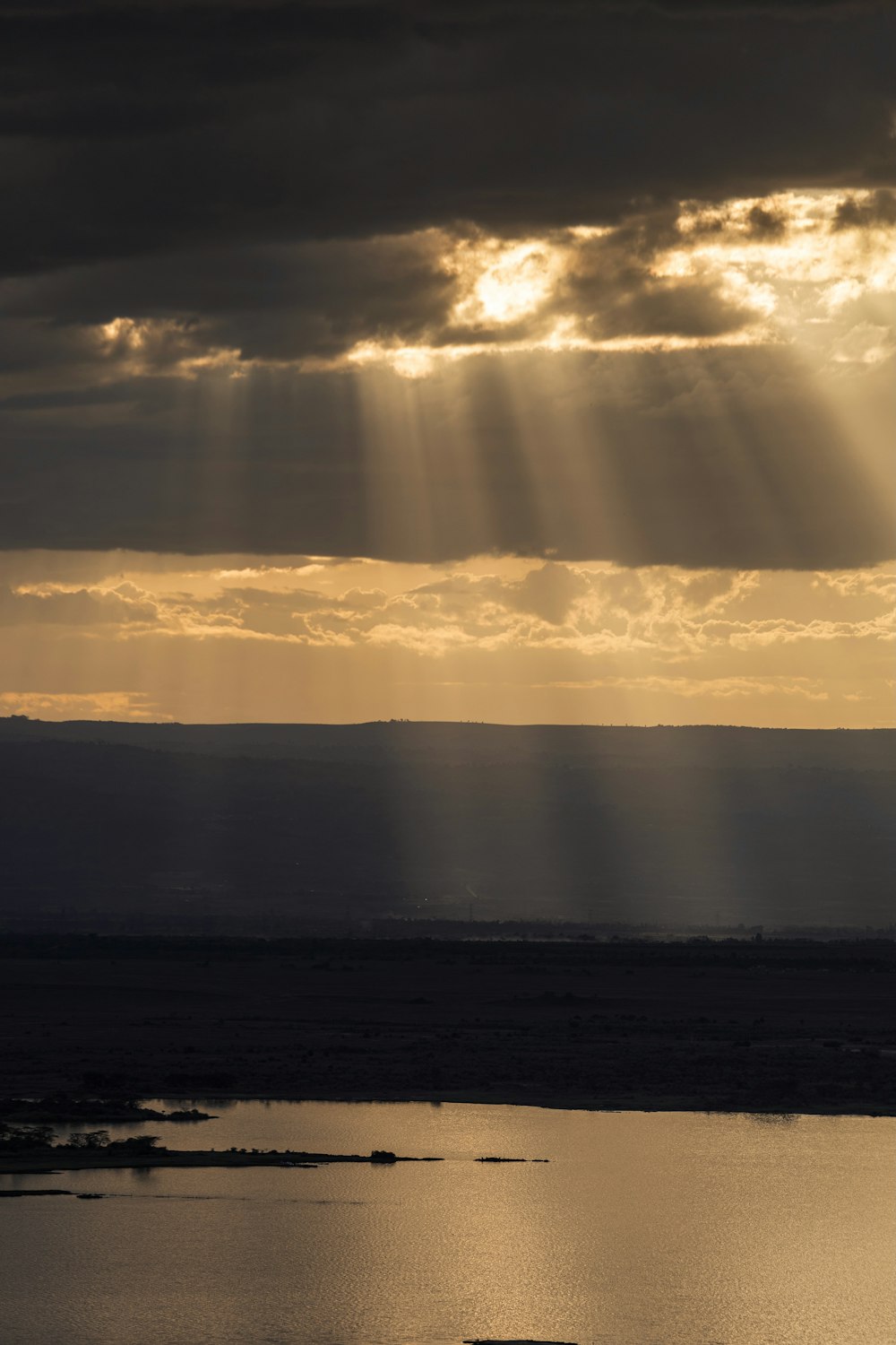 the sun shines through the clouds over a body of water