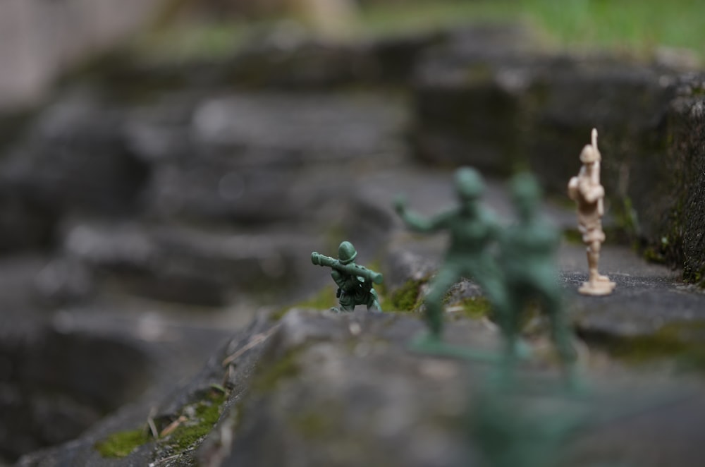 a group of toy soldiers standing on top of a rock