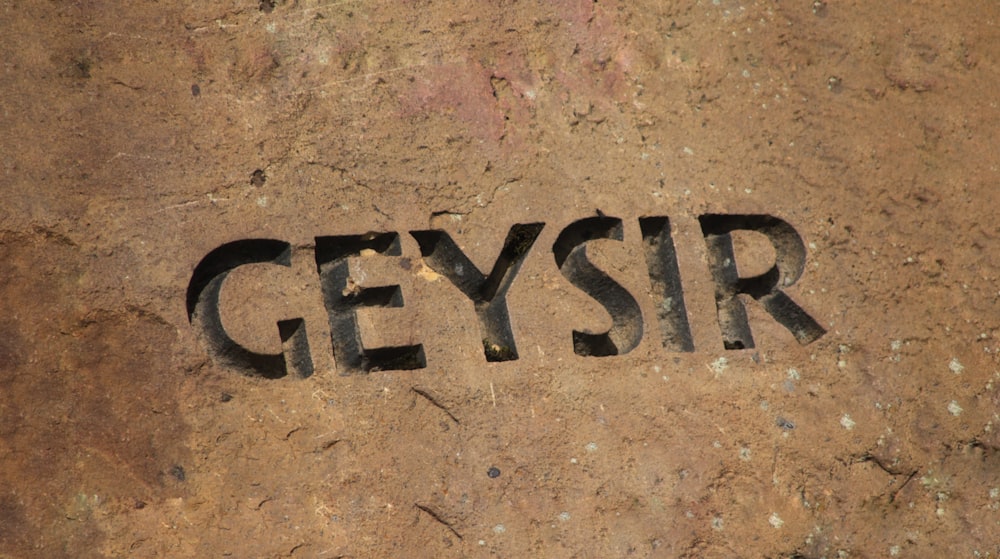 the word geysir written in black ink on a rock