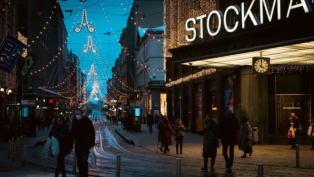 people walking down a city street at night