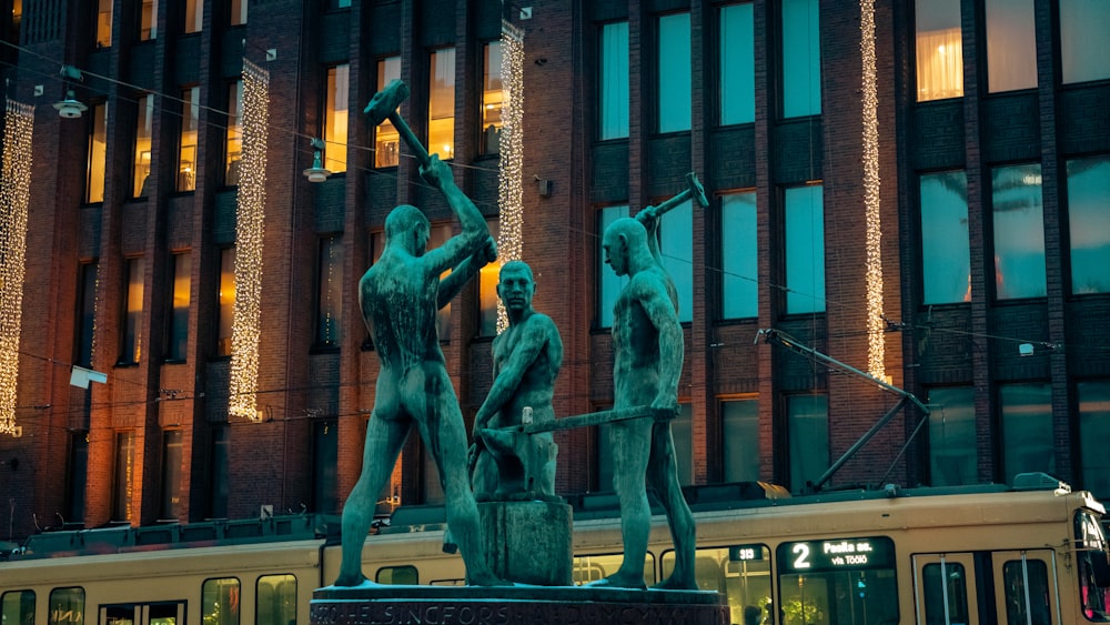 a statue of a group of people in front of a building