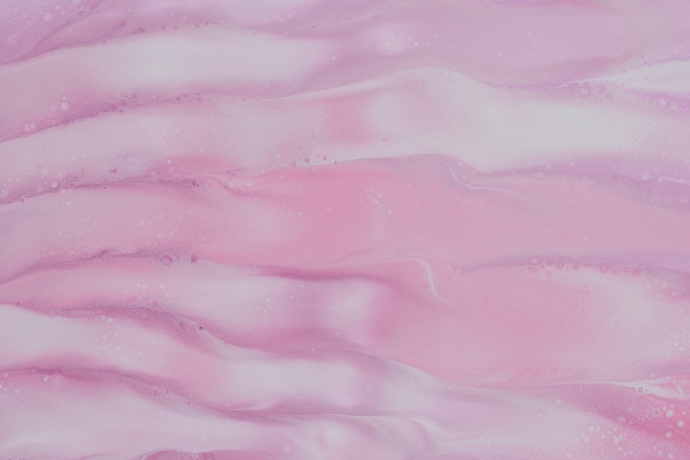 a close up of a pink and white background