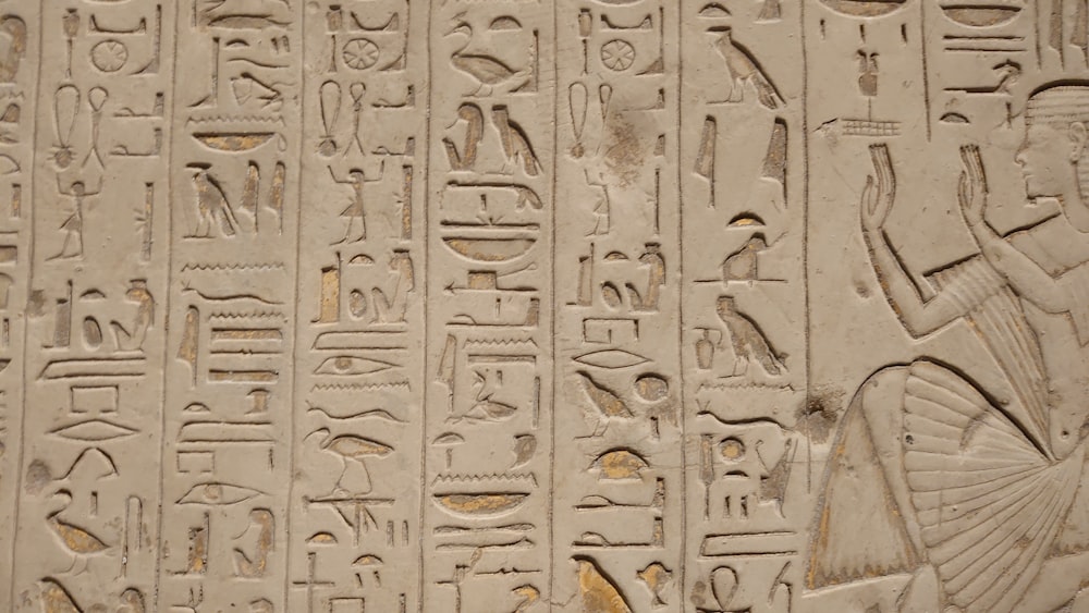 a close up of a wall with egyptian writing on it