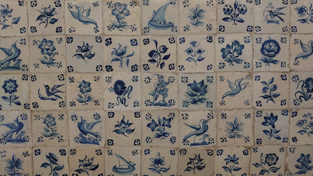 a blue and white tiled wall with flowers and birds
