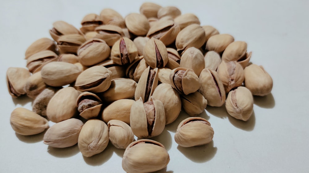 a pile of nuts on a white surface