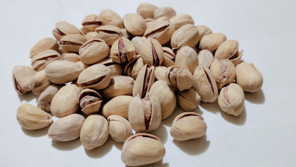 a pile of nuts on a white surface