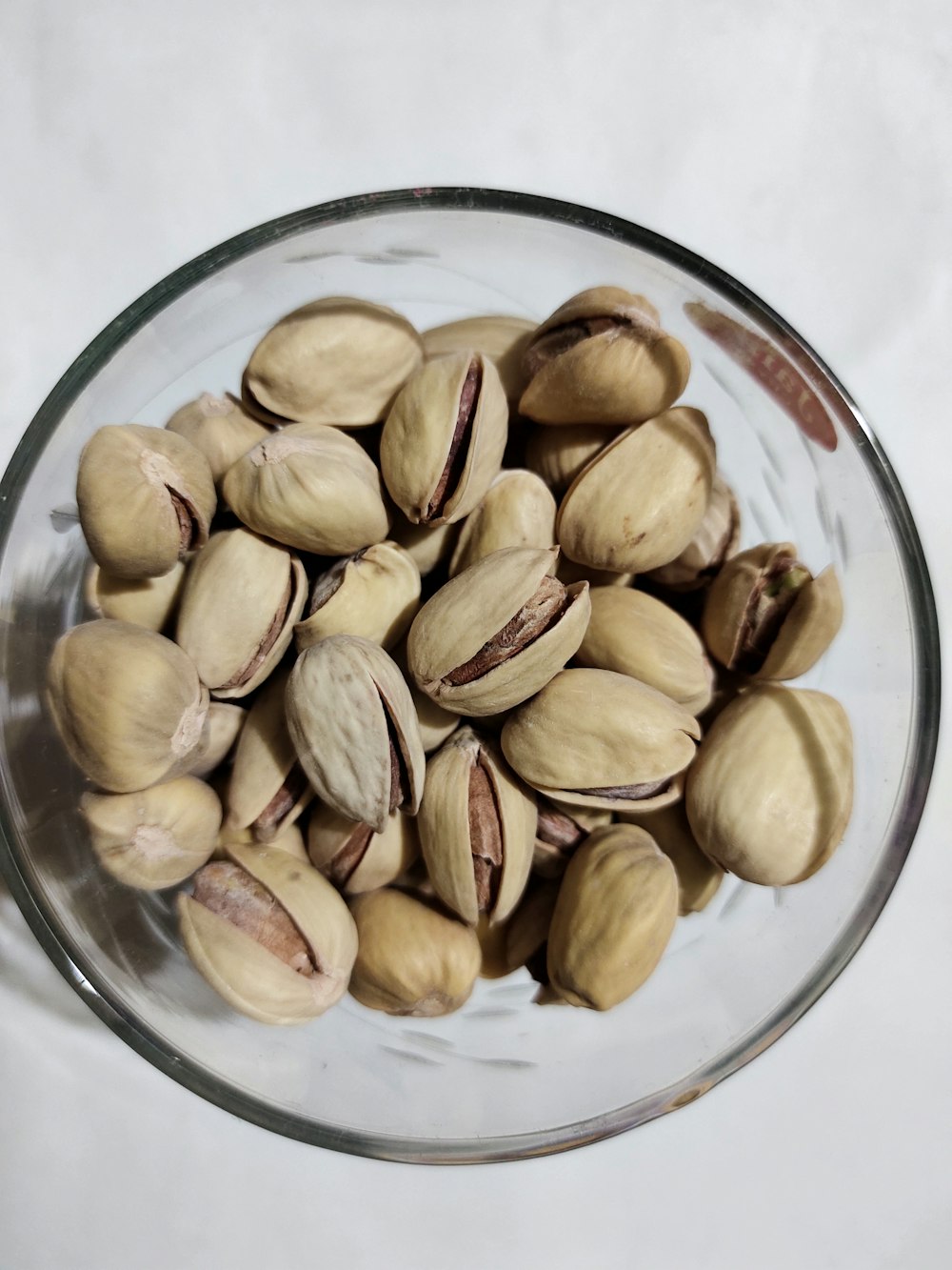 a glass bowl filled with nuts on top of a table