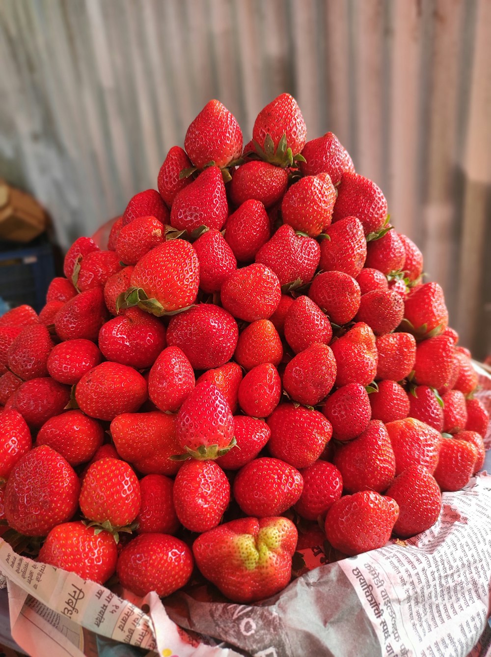 a pile of strawberries sitting on top of a newspaper