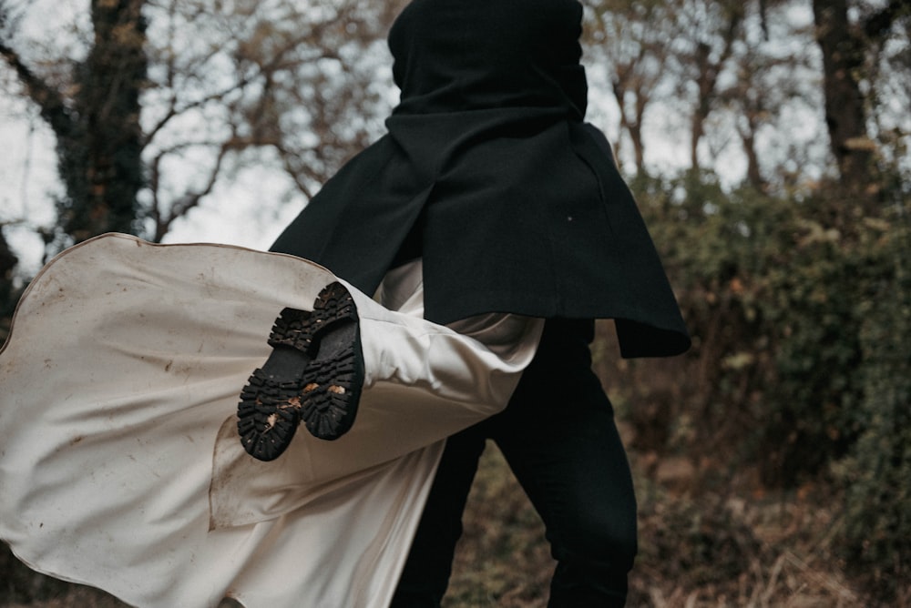 a person in a black coat carrying a white bag